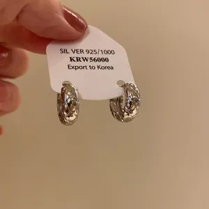 Detailed view of silver quilted texture hoop earrings on display card