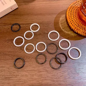 Macro view of several minimalist vintage style resin rings in neutral tones on wood.