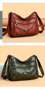 Detail view of multi-pocket soft leather shoulder bag in brown-red and olive green