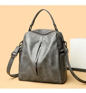 Close-up detail of a versatile grey vintage leather backpack featuring a front vertical zipper