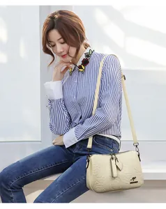 Elegant beige crossbody bag with rose embossed pattern and a stylish kangaroo logo.