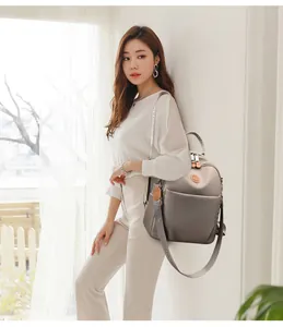 Zaino alla moda in nylon grigio con ampia tracolla jacquard indossato da una modella.