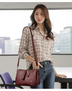 Elegant wine red crossbody bag with floral embossing shown on a stylish Asian model