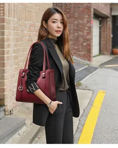 Elegant burgundy large capacity commuter tote bag worn by a professional woman