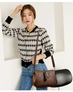 Elegant brown embossed rose handbag worn by an Asian model in an indoor setting