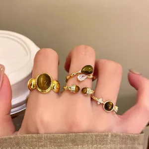 Vintage tiger eye stone rings in gold plating worn on fingers in a stack.