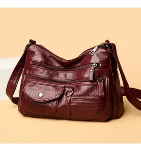 Detailed view of a fashionable burgundy multi-pocket crossbody bag with elegant stitching