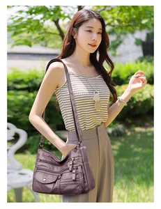 Fashionable purple faux leather crossbody bag with multiple zippers and embroidered details.
