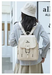 Vue arrière d'une femme portant un élégant sac à dos en cuir PU crème dans une rue.