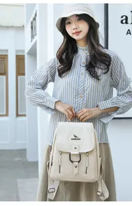 Détail d'un sac à dos en cuir PU crème avec logo kangourou et boucle métallique.