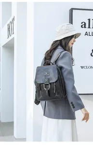 Mannequin portant un sac à dos en similicuir noir élégant dans un décor minimaliste.