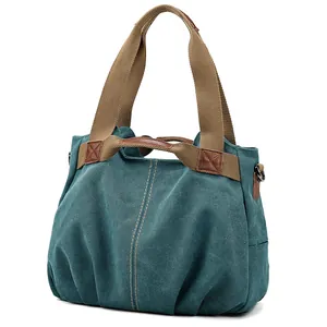 Retro teal canvas shoulder bag with large capacity and brown woven handles on white background