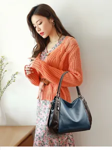 Elegant woman carrying a large blue soft leather shoulder bag in a lifestyle setting