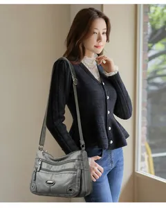 Asian model wearing a grey multi-pocket shoulder bag in a bright indoor setting