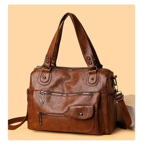 Detailansicht einer braunen Vintage Lederhandtasche mit mehreren Reißverschlüssen