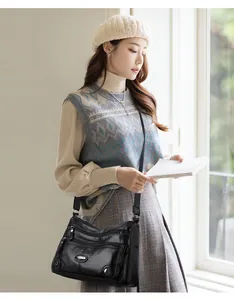 Elegant model carrying a black multi-pocket soft leather crossbody shoulder bag for women