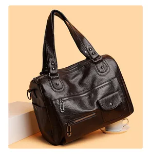 Detailansicht einer braunen PU-Leder Handtasche im Vintage-Stil mit vielen Reißverschlüssen.