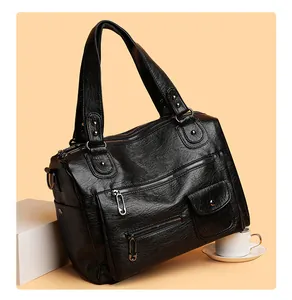 Detailansicht einer schwarzen PU-Lederhandtasche im Vintage-Stil mit vielen Reißverschlusstaschen