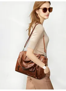 Detailansicht einer braunen Vintage-Handtasche aus PU-Leder, von Model getragen.