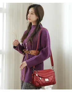 Elegante borsa a tracolla rossa in morbida pelle trapuntata da donna in una scena di vita