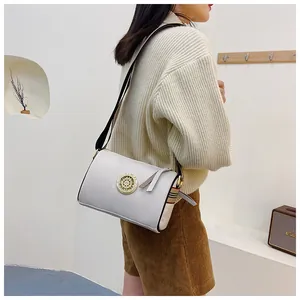 Dettaglio di una borsa a tracolla in pelle bianca con fibbia dorata vintage.