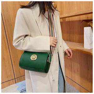 Dettaglio di una borsa a botte vintage in vera pelle verde con tracolla a quadri elegante