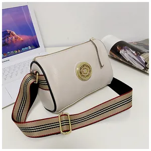 Dettaglio della borsa a cilindro vintage in pelle bianco crema con tracolla a righe