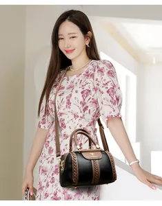 Elegant color-block women's handbag with kangaroo logo shown on a fashion model.