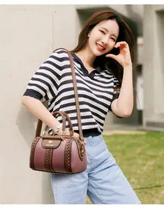 Detailed view of women's color-block handbag with braided straps and kangaroo logo.