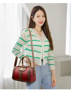 Fashionable red and brown textured leather handbag shown on a model in a detail view