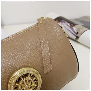 Dettaglio borsa in pelle martellata marrone chiaro con fibbia dorata