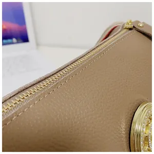 Primo piano della trama in pelle martellata e della cerniera dorata della borsa