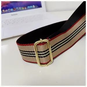 Dettaglio di tracolla di ricambio vintage a strisce beige e rosse con fibbia dorata