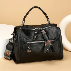 Elegant black pebbled leather Boston bag with colorful patterned strap and handle