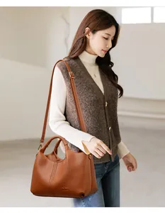 Elegant brown textured leather handbag for women carried by a model in a casual setting