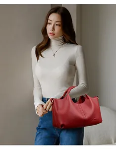 Elegant red pebbled leather handbag held by a model for a stylish and casual look