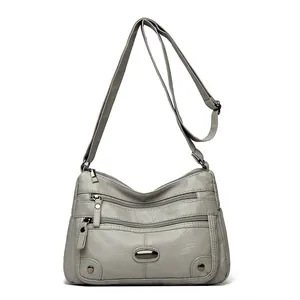 Elegante borsa a tracolla grigia da donna con tasche multiple e tracolla regolabile.