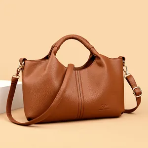 Elegant brown faux leather women's handbag with top handle and crossbody strap