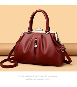 Detail einer eleganten weinroten Handtasche aus Leder mit Metallverschluss
