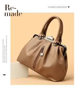 Detail einer eleganten braunen Ledertasche mit Metallrahmenverschluss und Anhänger