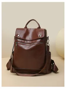 Close-up of a vintage brown leather backpack with textured finish and zipper detail.