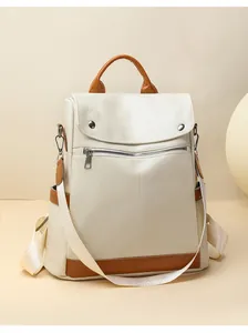 Close-up of elegant off-white women's anti-theft backpack with brown leather accents.