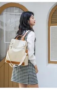 Stylish cream anti-theft backpack for women worn by a model in a street setting.