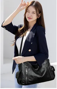 Large vintage black soft leather shoulder bag for women styled with a casual outfit.