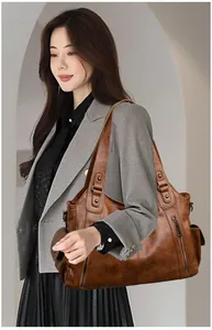 Detail of vintage brown soft leather tote bag carried by a professional woman