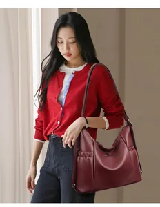 Asiatisches Model trägt eine burgunderrote große Ledertasche für einen lässigen Business-Look.