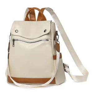 Elegant women's anti-theft backpack in beige and brown faux leather for travel and daily use.