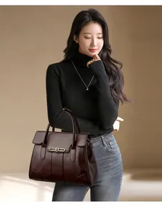 Professional model showcase of an elegant large brown leather handbag in a studio setting