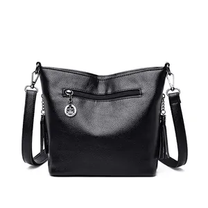 Black soft leather shoulder crossbody bag for women featuring crown charm and tassels