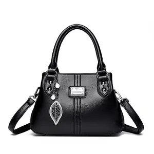 Elegant black textured leather handbag for women with silver leaf charm and top handle